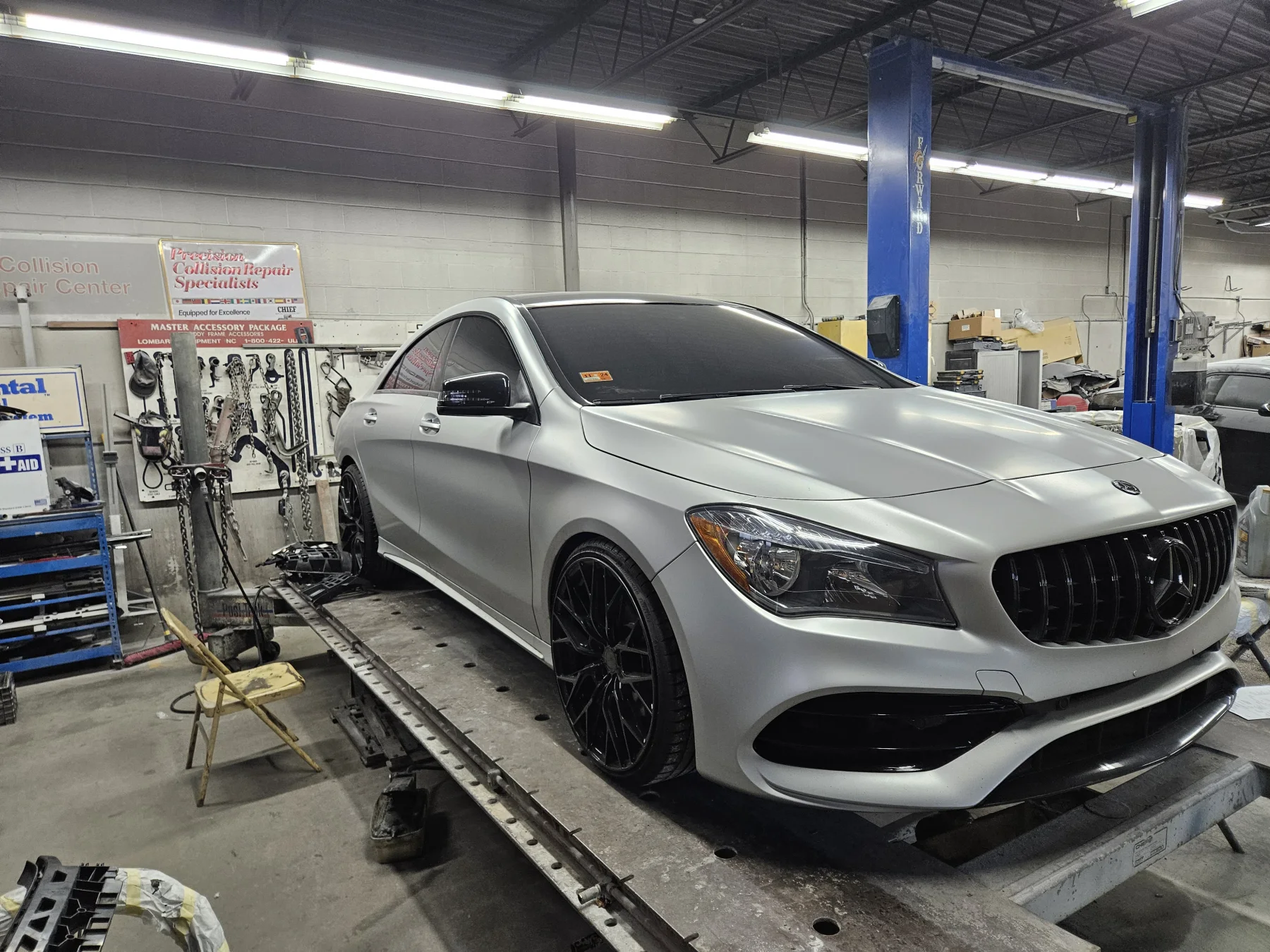 Silver Mercedes positioned on a frame machine inside Delta Auto